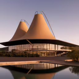 a building with a pyramid shaped design next to water