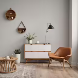 two round wooden chairs next to an old, white cabinet in a grey room