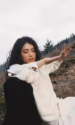a woman sitting down while making peace with her hands