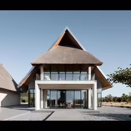 a large white building has a thatched roof
