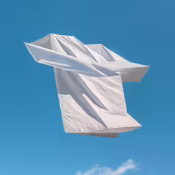 an airplane flying in the blue sky and a white object