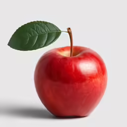 a ripe apple with a leaf resting on it