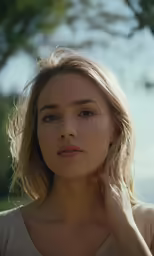 a girl standing with her hand under her ear