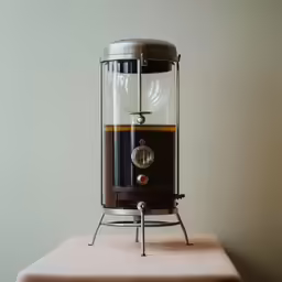 a small machine has an empty glass container for water