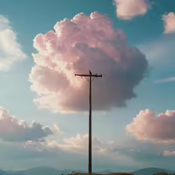 an electrical pole with a cloud in the sky behind it