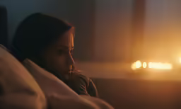 a young girl is looking into the distance while lying down