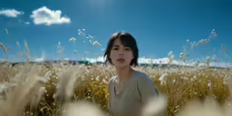 the woman stands in the middle of tall grass