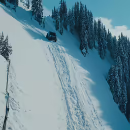 a truck is traveling down a snow covered mountain side