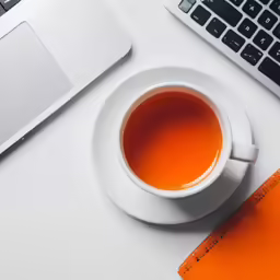 a cup of tea and a notebook on a white table