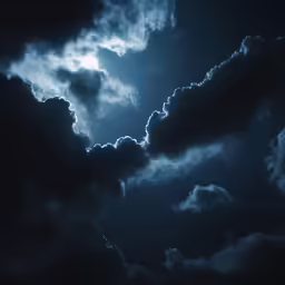 a dark blue cloud with a bright light shining down on the top