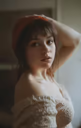 a young woman poses for a photograph with a red hat on her head