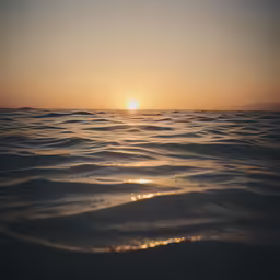 there are some waves on the water at sunset