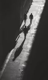 shadows on the street and some people walking down