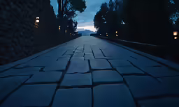 a walkway is lined with lights near a large rock