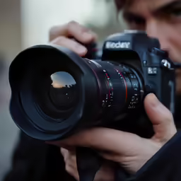 a man holding a camera up to take a picture