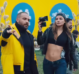 two people wearing jackets are taking pictures