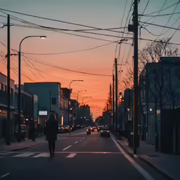 a woman walks down the road at sunset