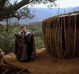 a man in black robes on top of a hill