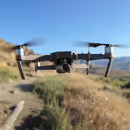 a grey and black flying object above a field