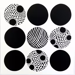 a close up of many black and white circular shapes,black and white artwork on a white wall
