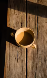 a cup of coffee is on a wooden table
