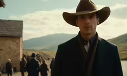 a man in a cowboy hat standing next to a crowd