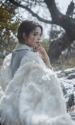 a woman in a white gown sitting on the ground