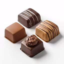 four chocolate pieces are shown on a white surface