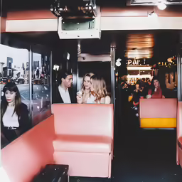 a group of people sitting in a bus with their feet up