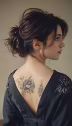 a young woman with a tattoo on her back