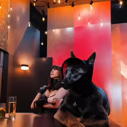 a woman in corsects sits beside a dog