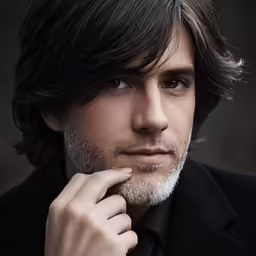 man with long hair and mustache looking at camera