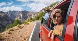 the young girl is sitting in her red car