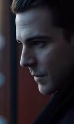 a man with black hair stares ahead with the dark eyes