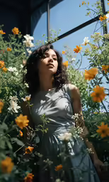 a woman standing in front of flowers near a window