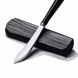 a black knife on top of a knife board