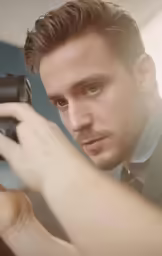a man holding a camera while staring at something