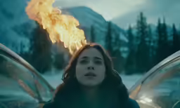 a woman is shown in front of a car with flames coming out of it