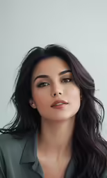 a woman wearing green and wearing a pair of earrings