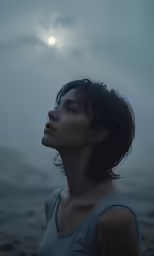 the woman is staring into the distance on the beach