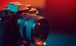 a digital camera is sitting next to an empty cup