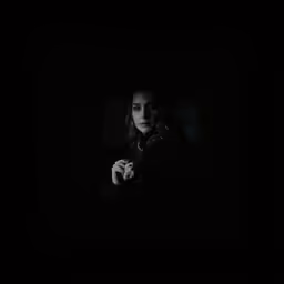 a woman standing in the dark in the dark