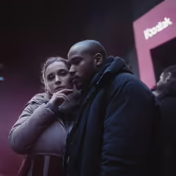 a man and woman standing outside in the dark