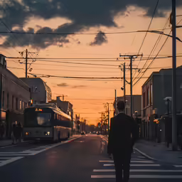 a man walking across the road as the sun sets