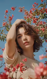 a woman posing for a photo with red flowers
