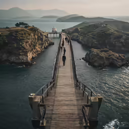 several people walking on the boardwalk over water