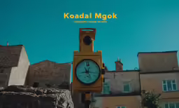 there is a yellow stop light with a clock in front