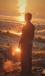 a person standing in front of the ocean at sunset