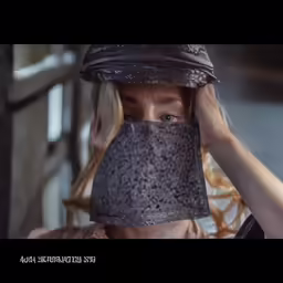a woman covering her face with a brown paper