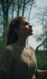 a woman looking to her left while holding something in one hand